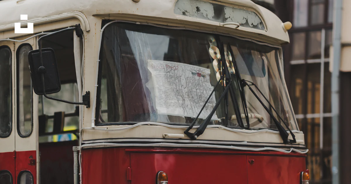 A red and white bus driving down a street photo – Free Vehicle Image on ...