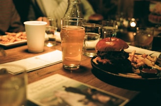 A wooden table topped with plates of food and drinks