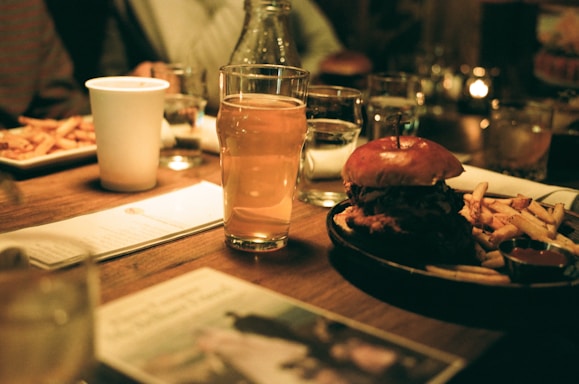 A wooden table topped with plates of food and drinks