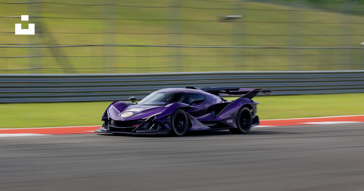 Purple Car Racing A purple race car driving down a race track photo – Free Zonda Image on ...