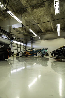 A garage with three cars parked in it