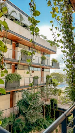 An apartment building with plants growing on the balconies