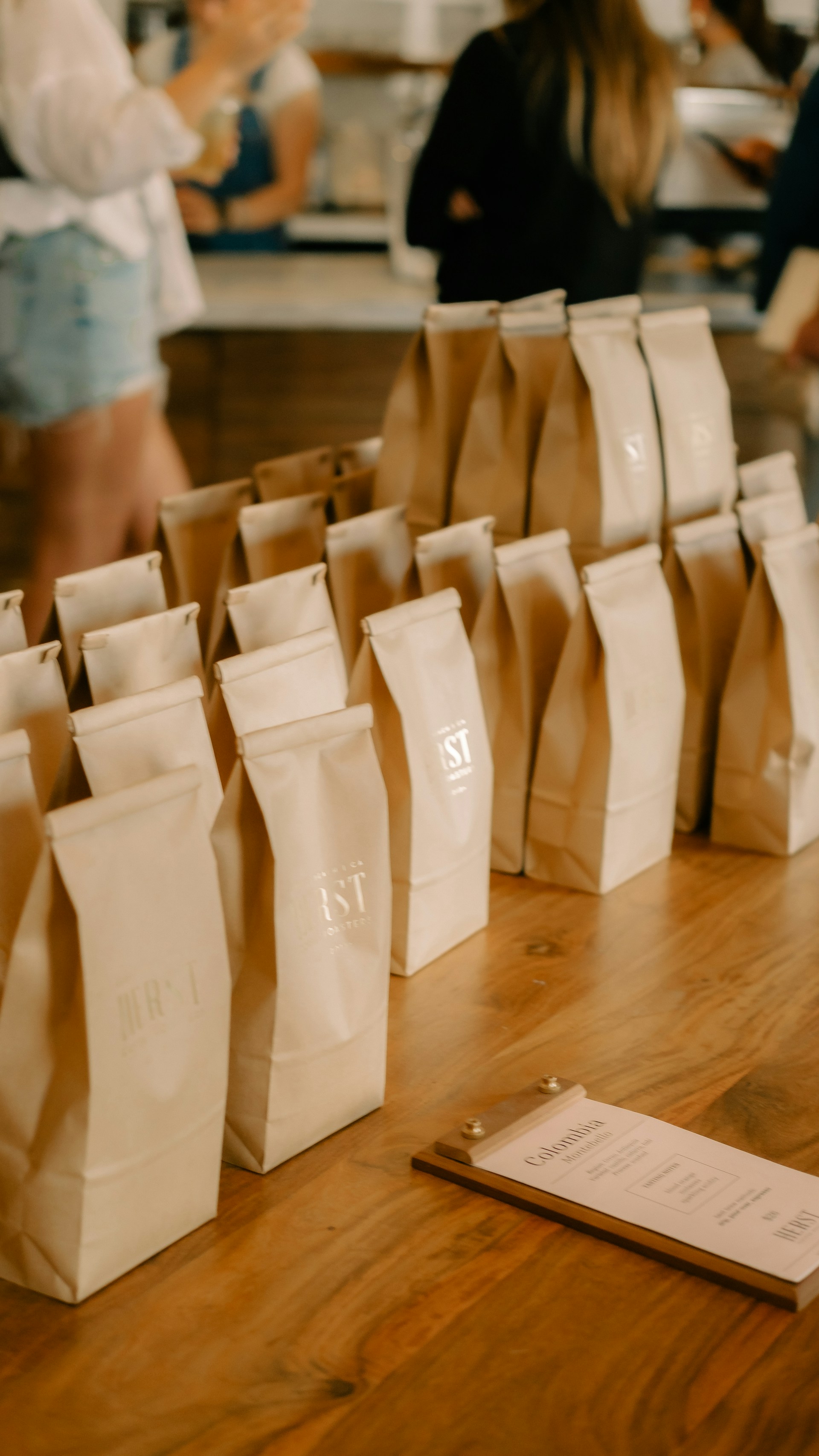 A group of bags of coffee sitting on top of a wooden table