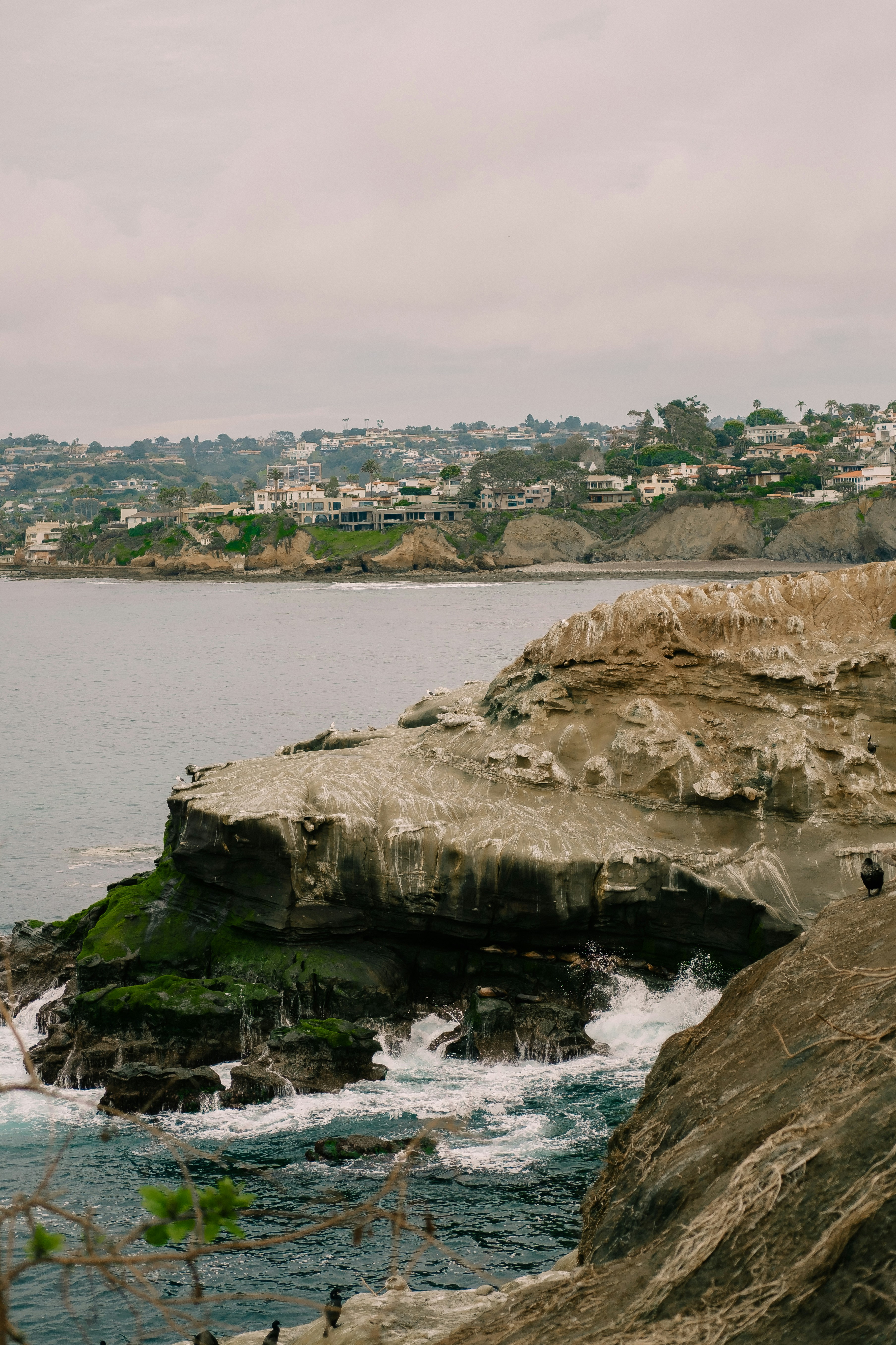 A man standing on top of a cliff next to the ocean