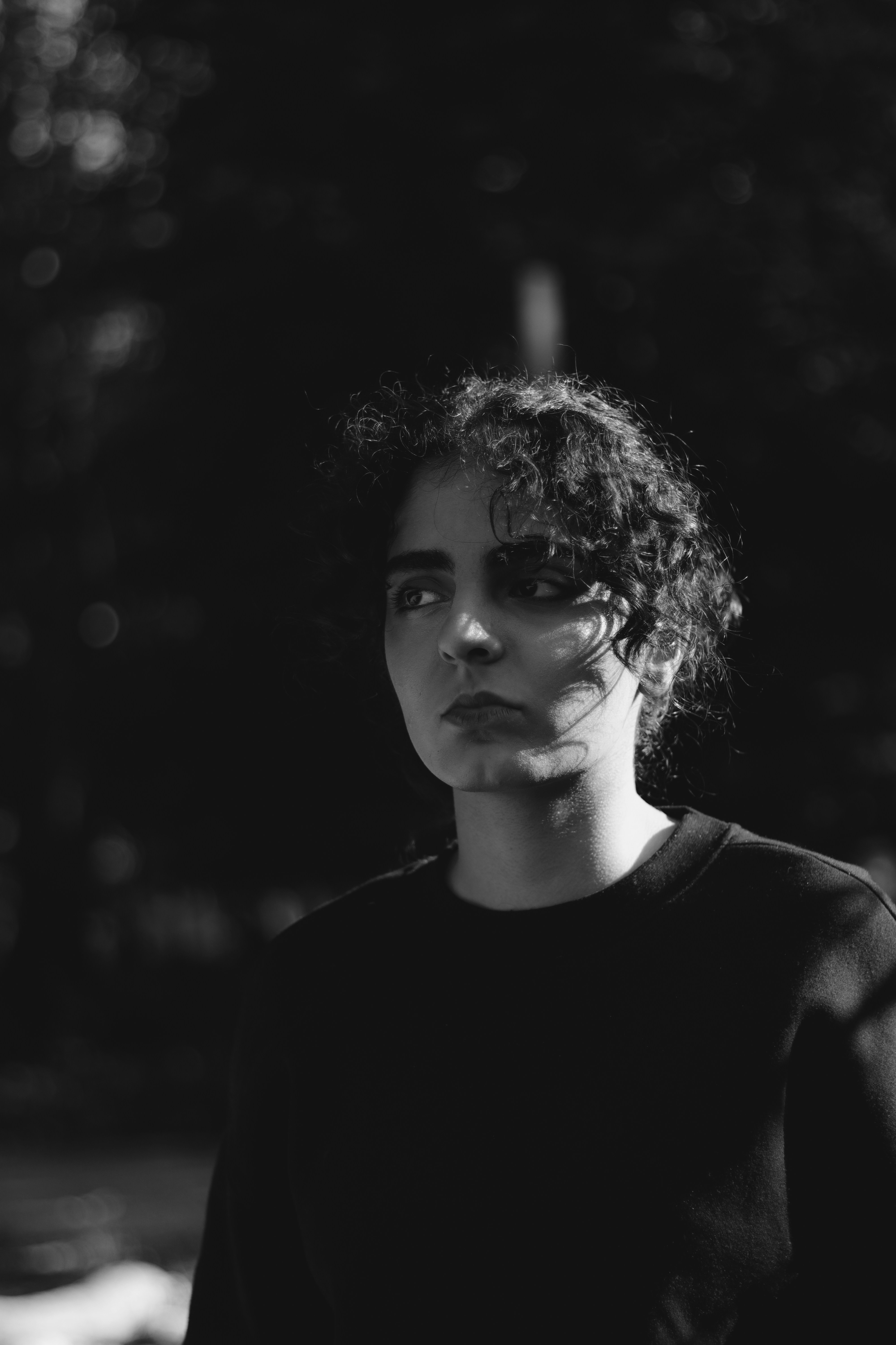 A black and white photo of a woman with curly hair