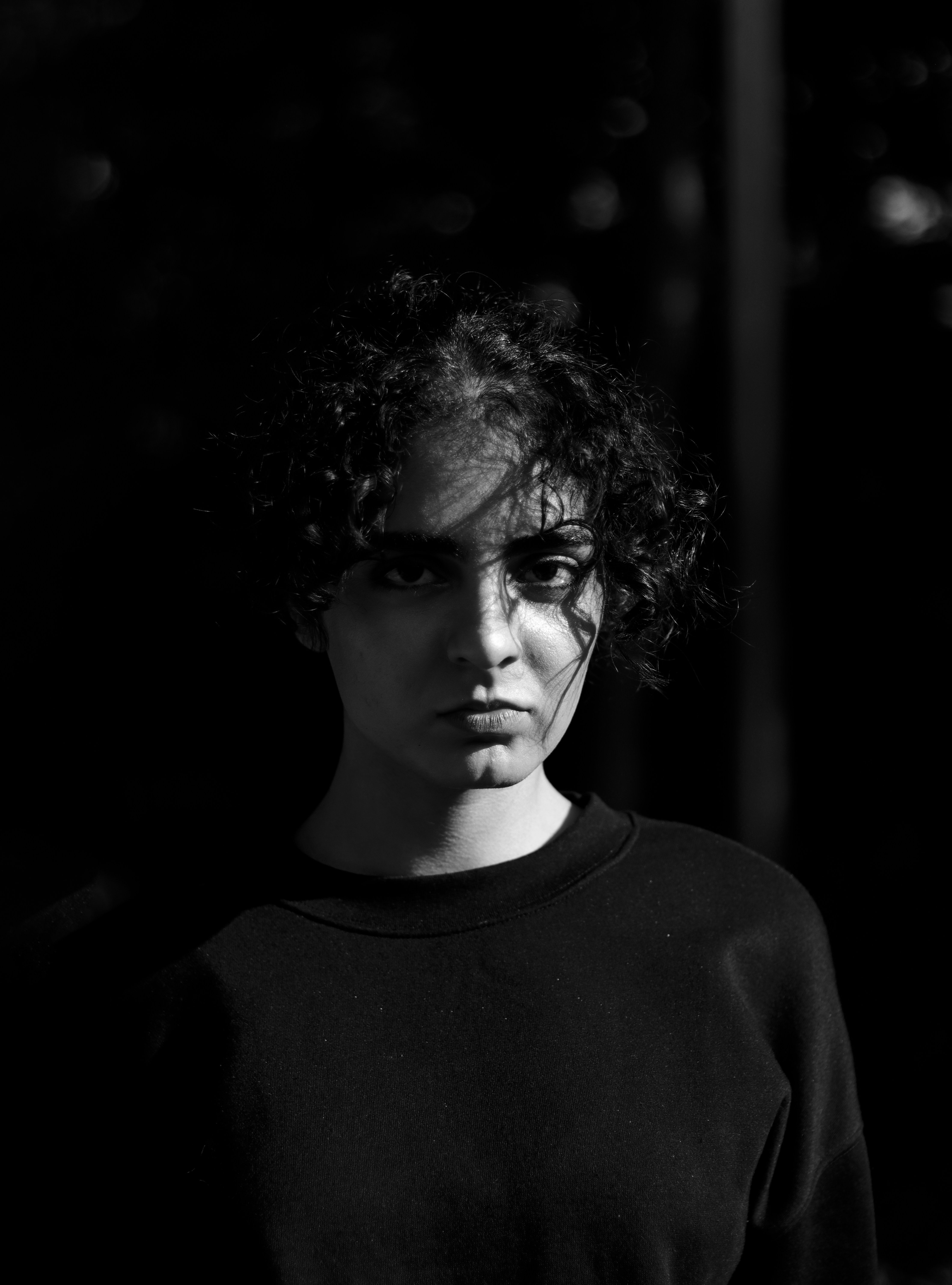 A black and white photo of a woman with curly hair