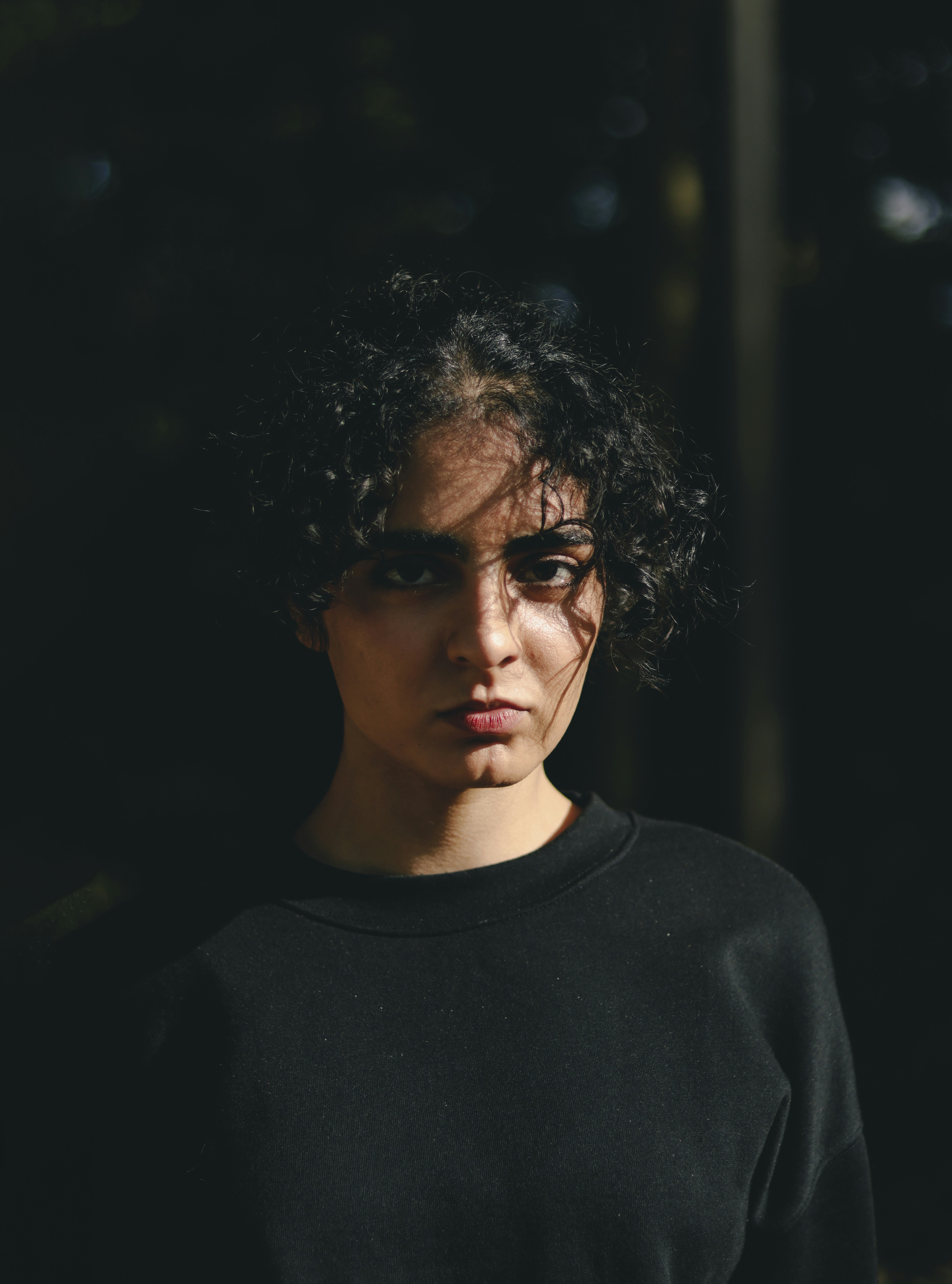 A woman with curly hair wearing a black shirt