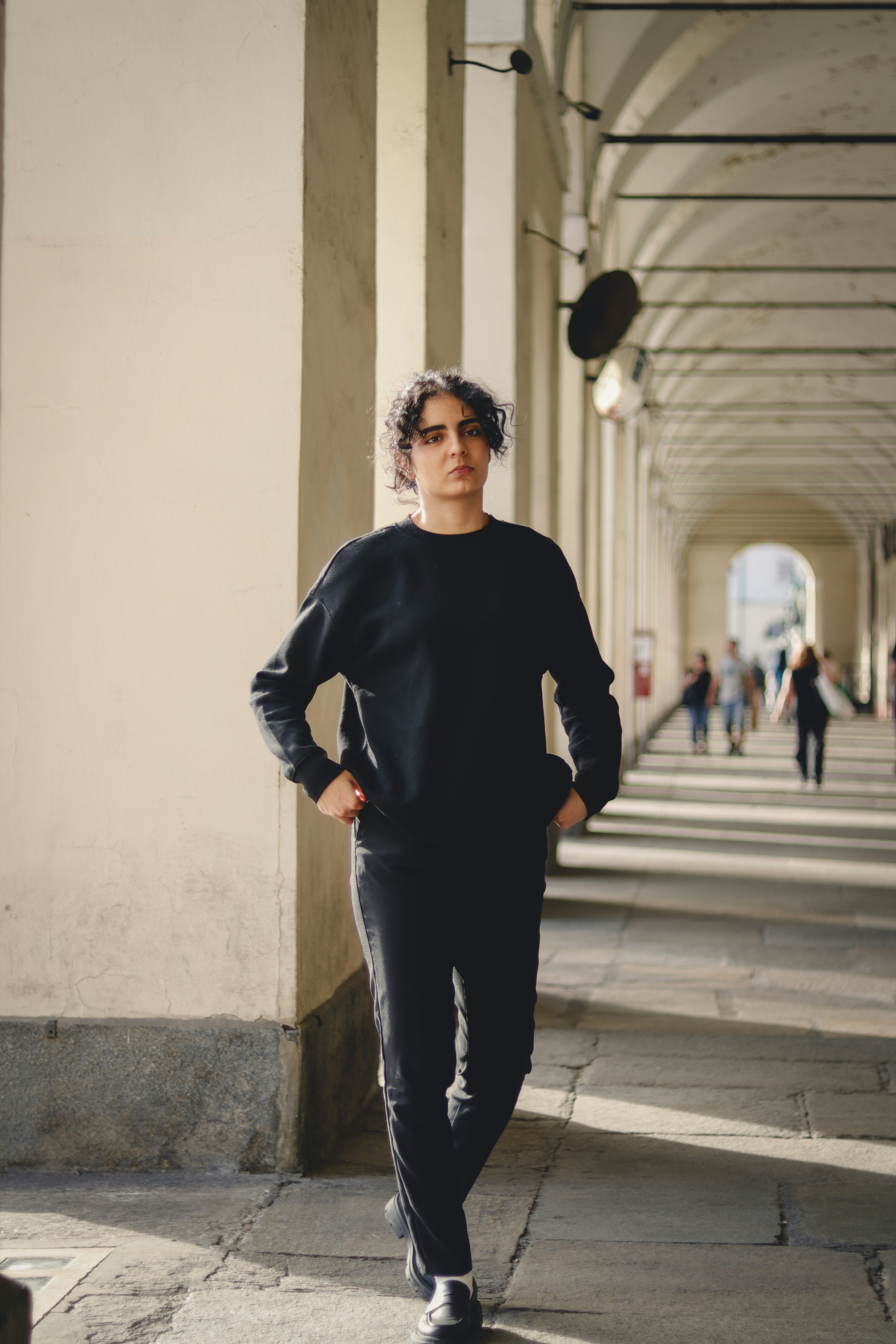 A man standing in a hallway with his hands on his hips