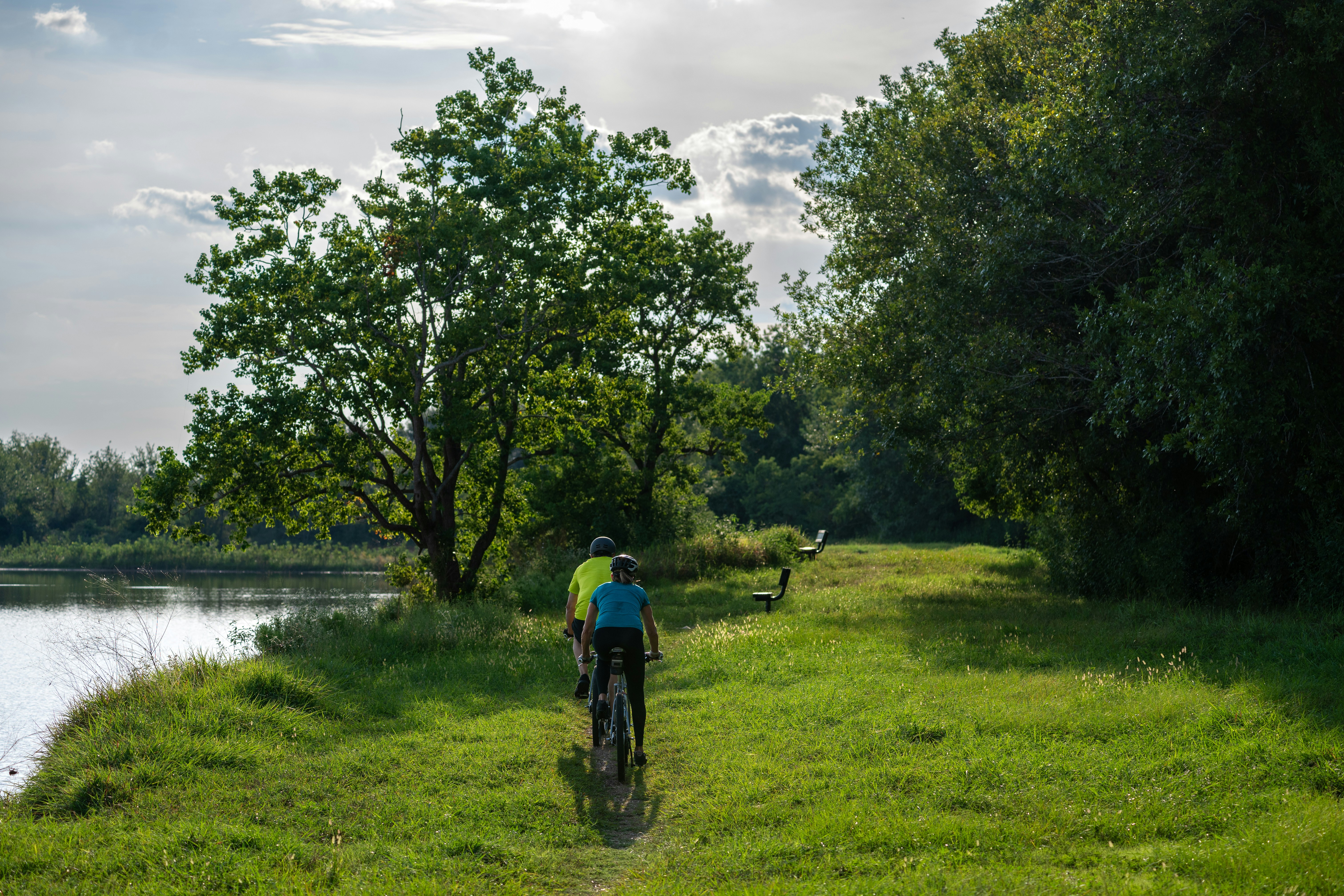 A person riding a bike on a path near a body of water