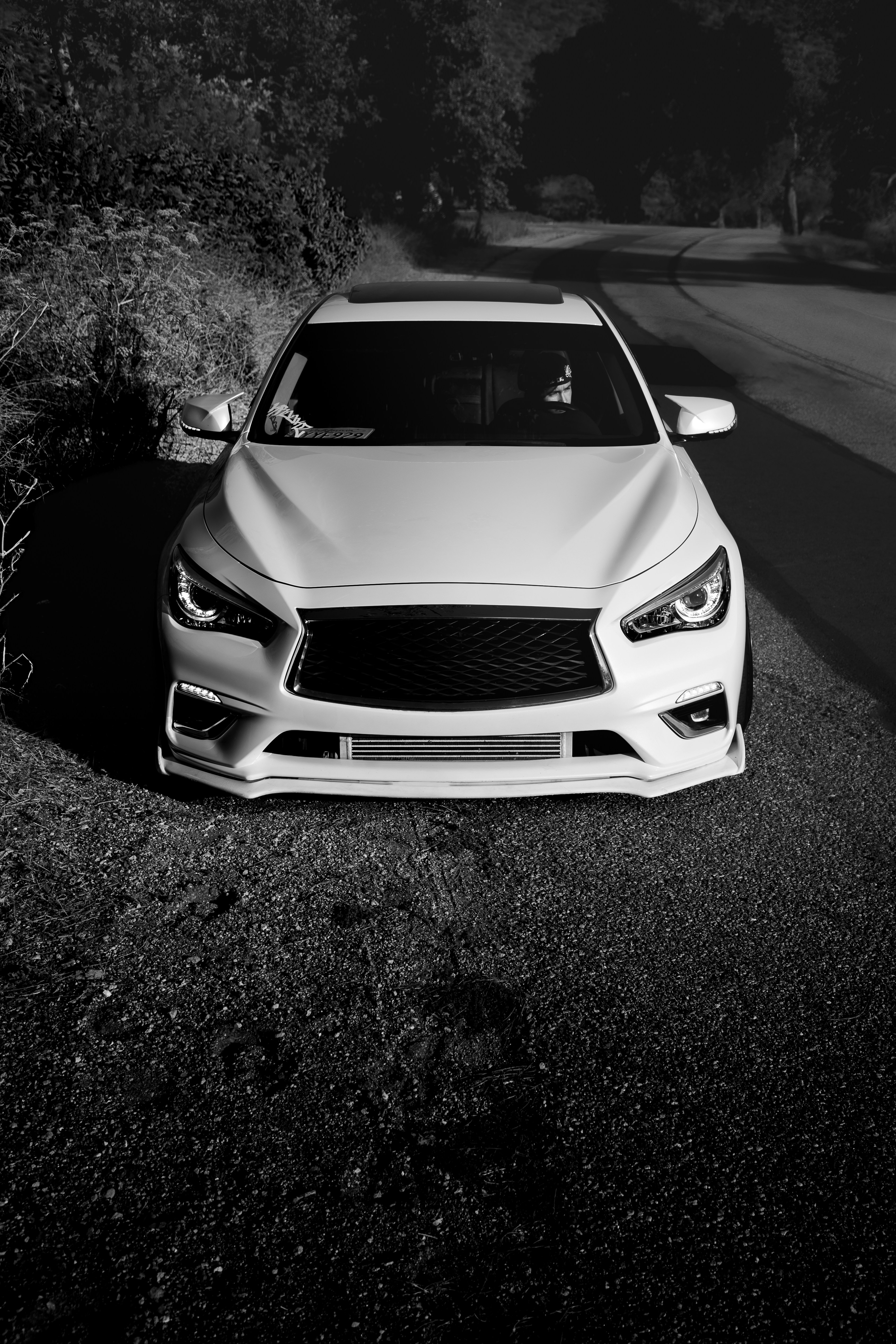 A white car parked on the side of a road