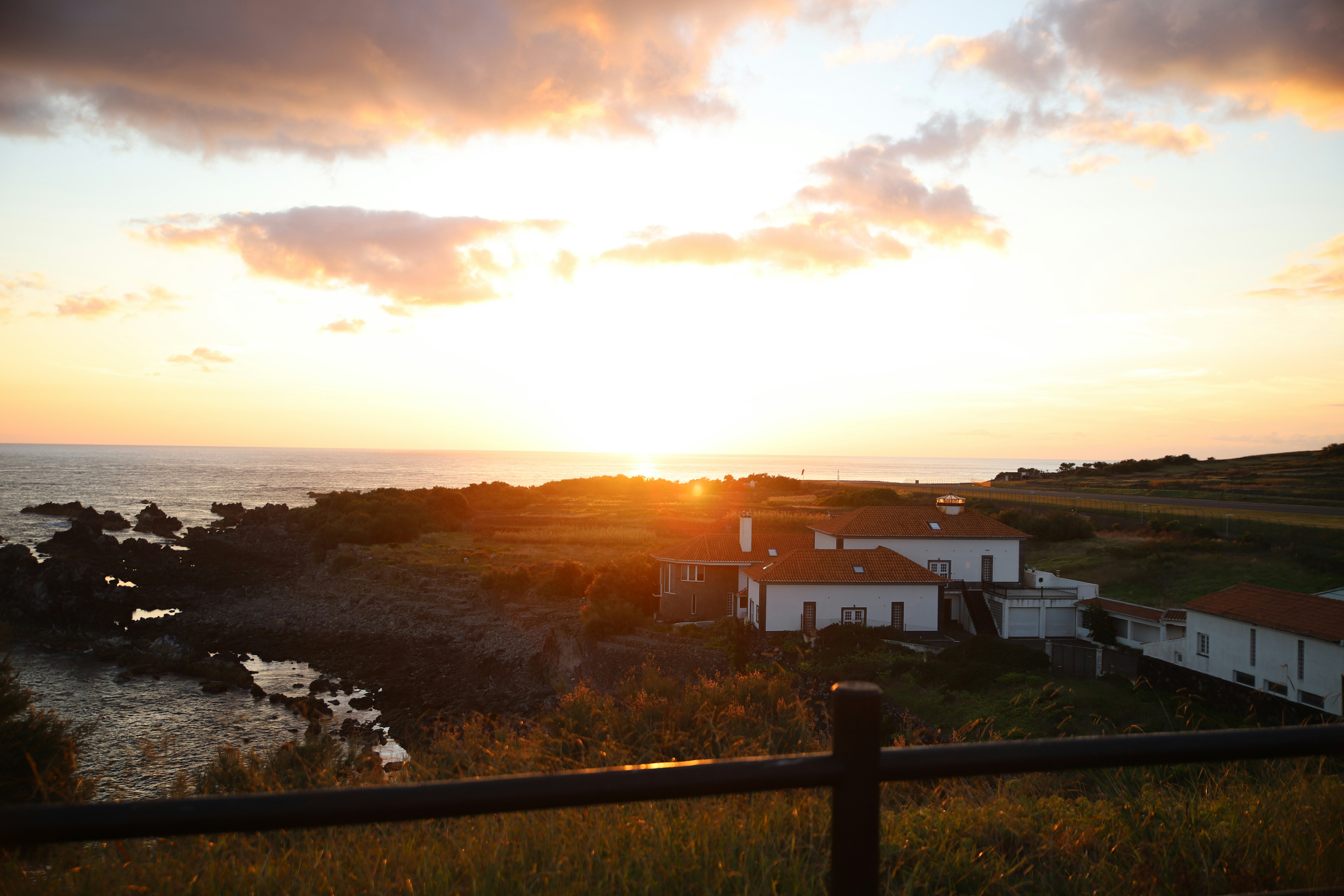 The sun is setting over a small town by the ocean