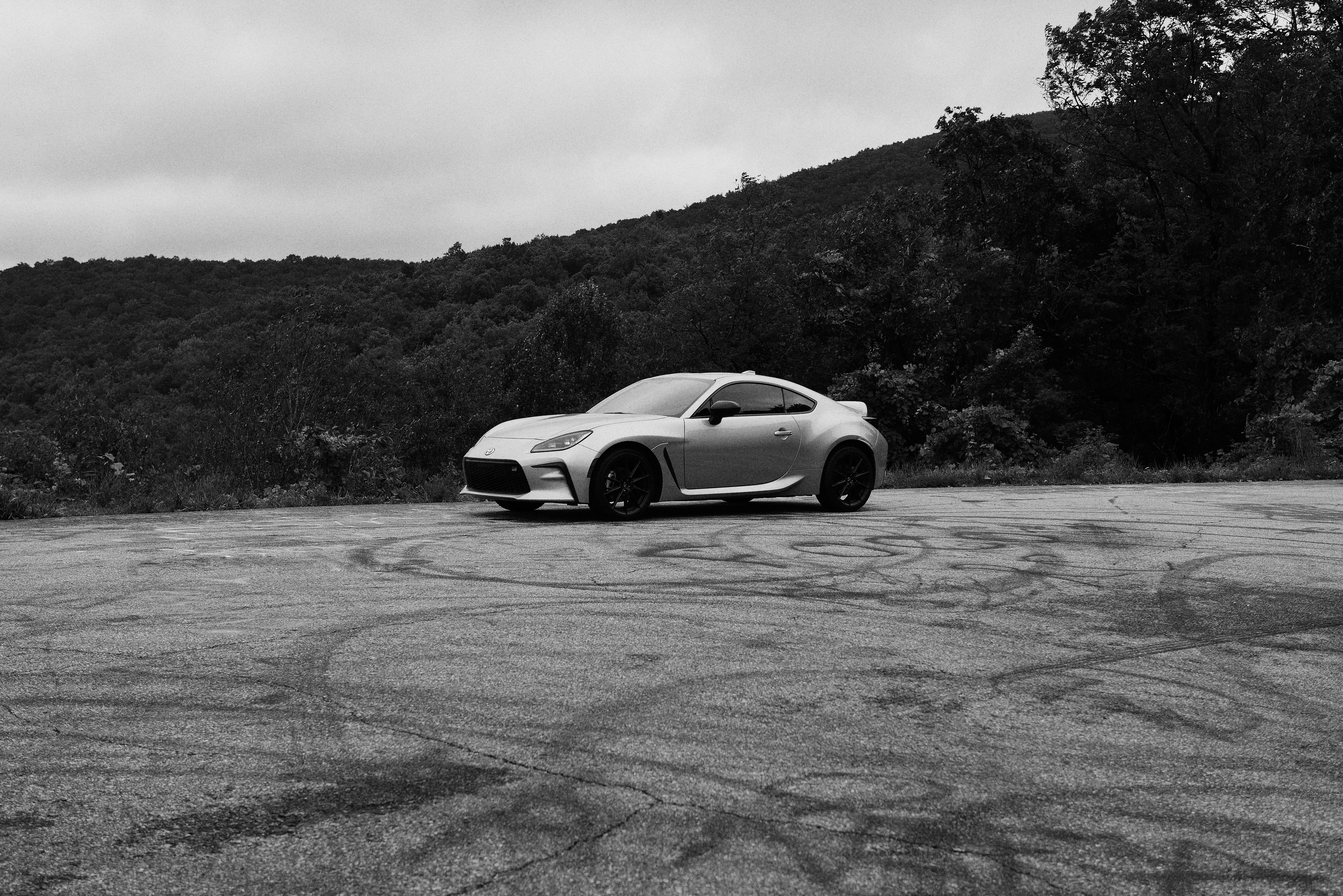 A car parked in a parking lot next to a mountain