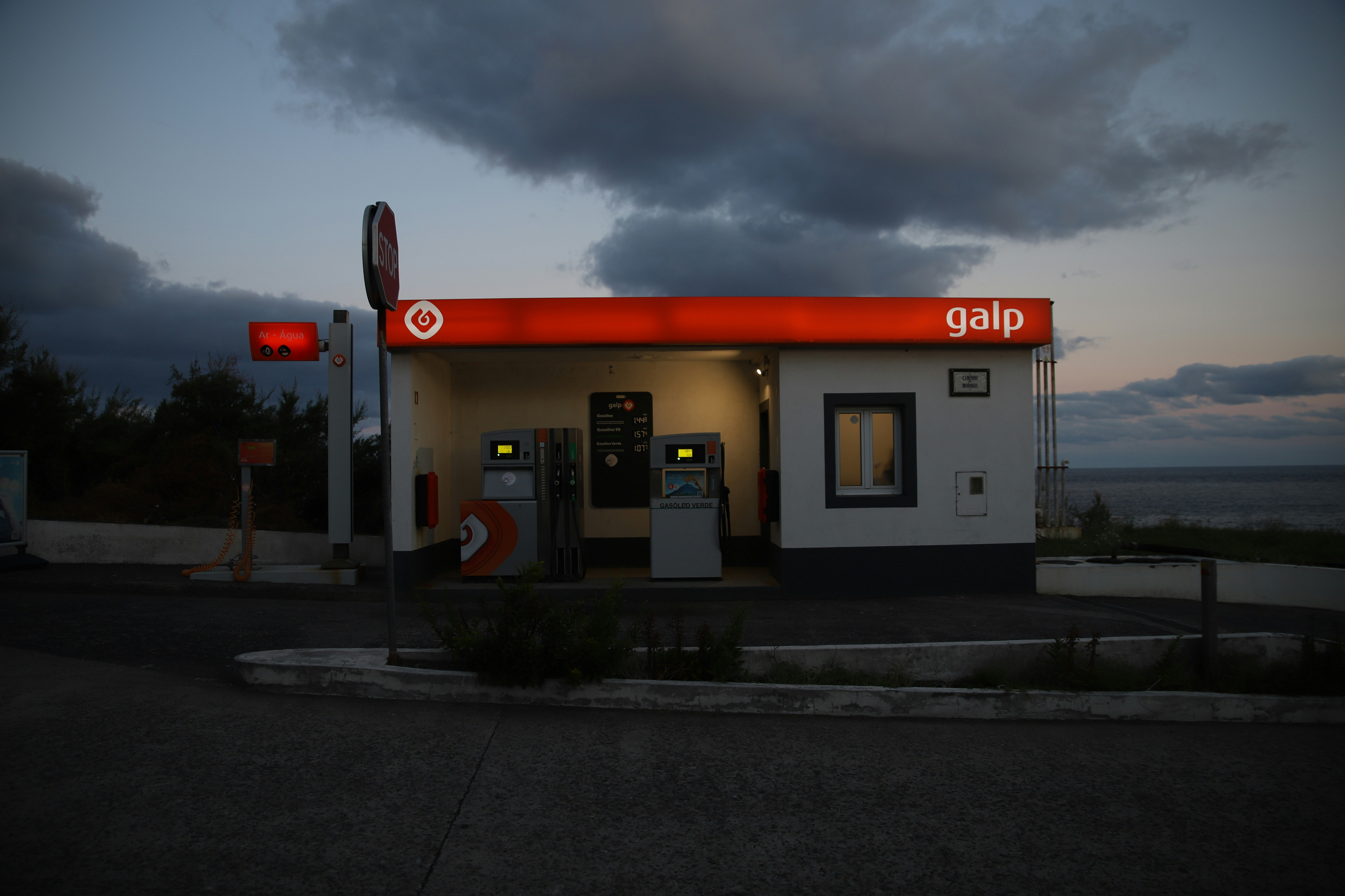 A gas station at dusk with a cloudy sky