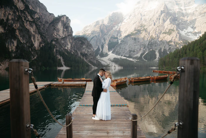 A bride and groom on a wooden jetty on a mountain lake