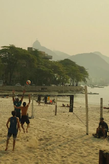 A group of people playing volleyball on a beach