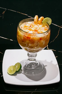 A glass of food on a plate on a table
