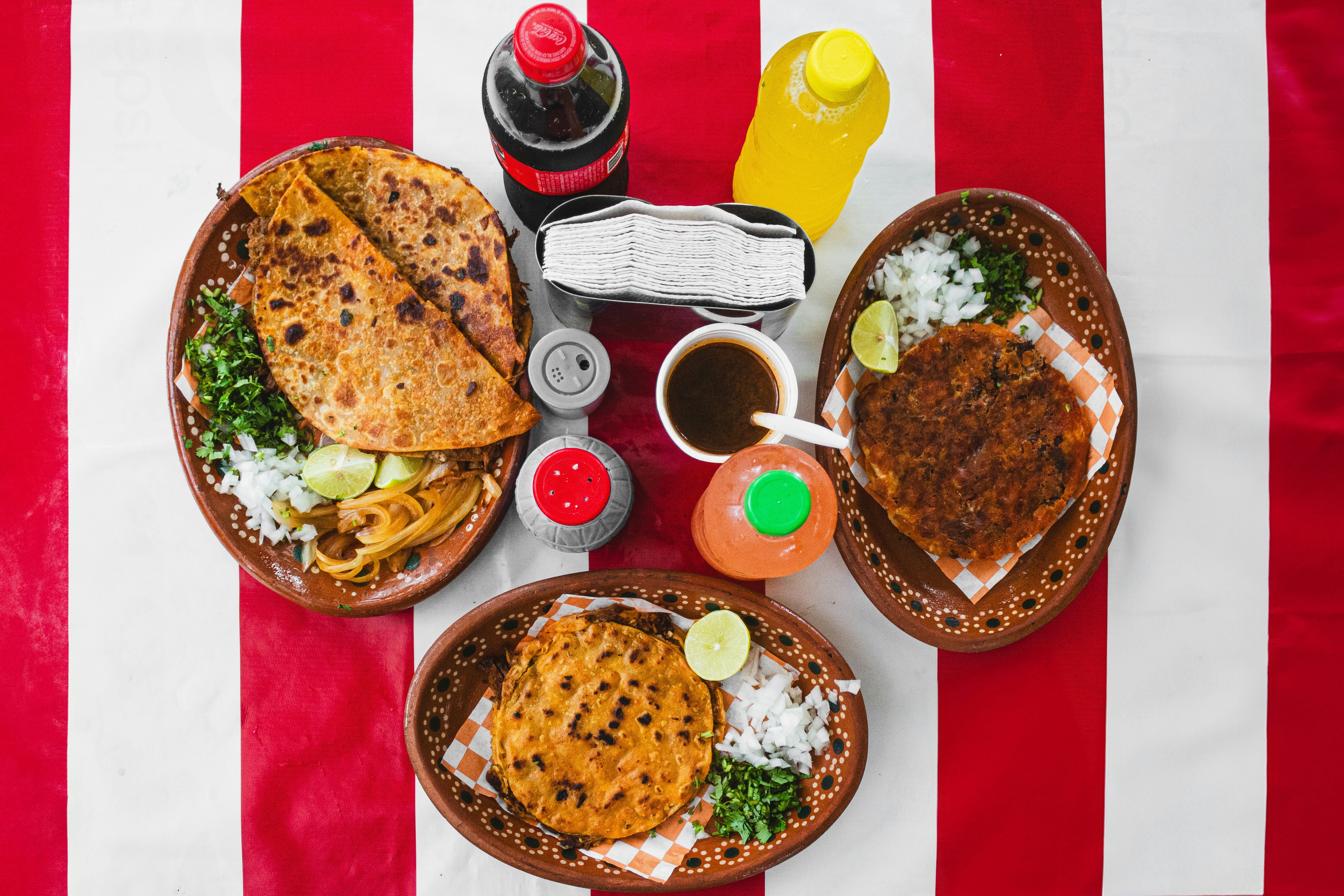 A table topped with plates of food on top of a red and white striped table