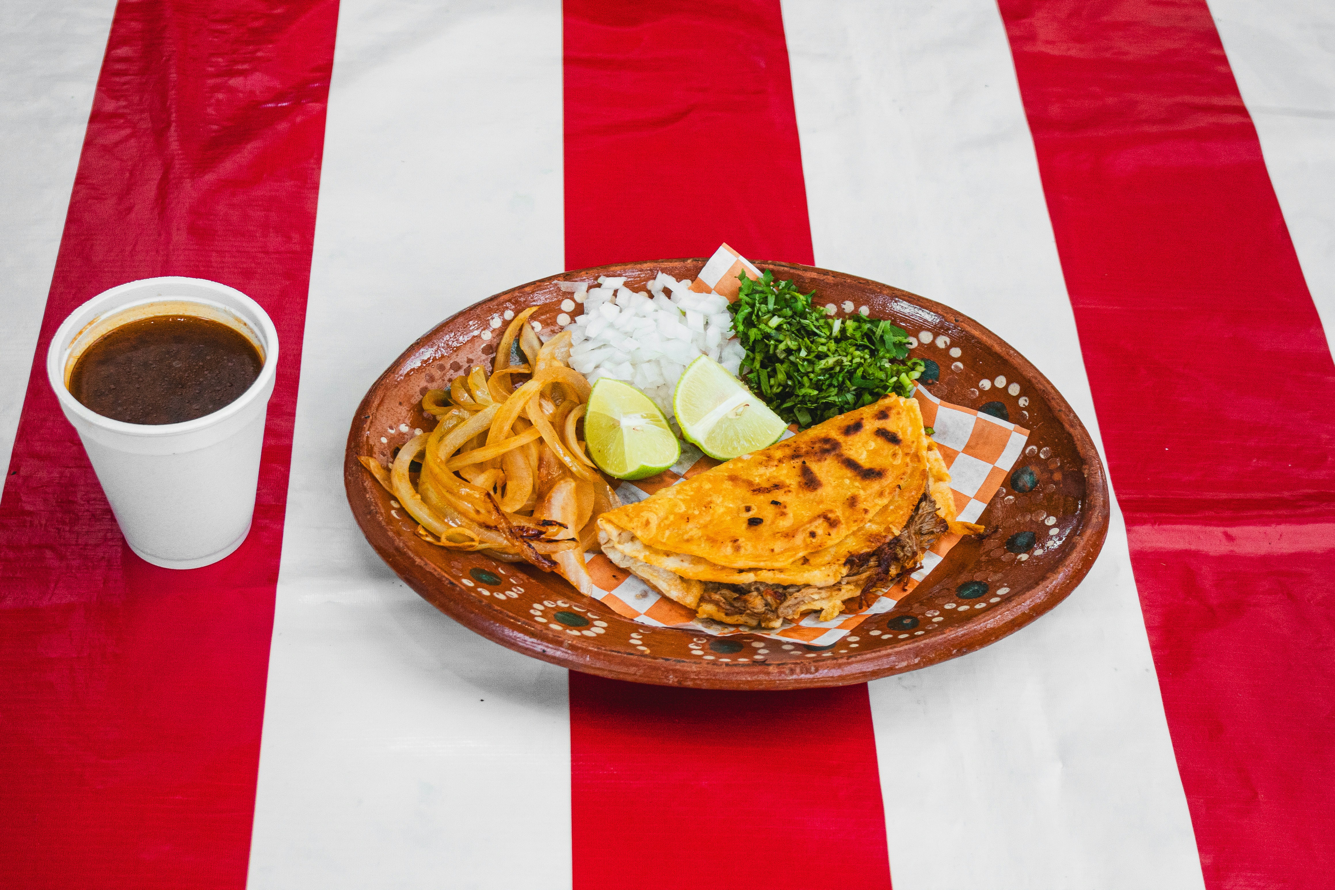 A plate of food on a table with a cup of coffee