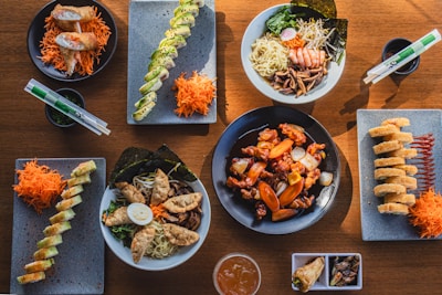 A wooden table topped with plates of food
