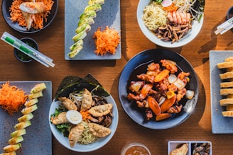 A wooden table topped with plates of food