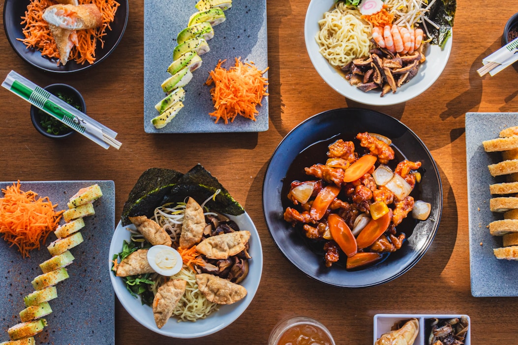A wooden table topped with plates of food