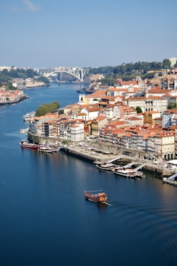 A boat traveling down a river next to a city