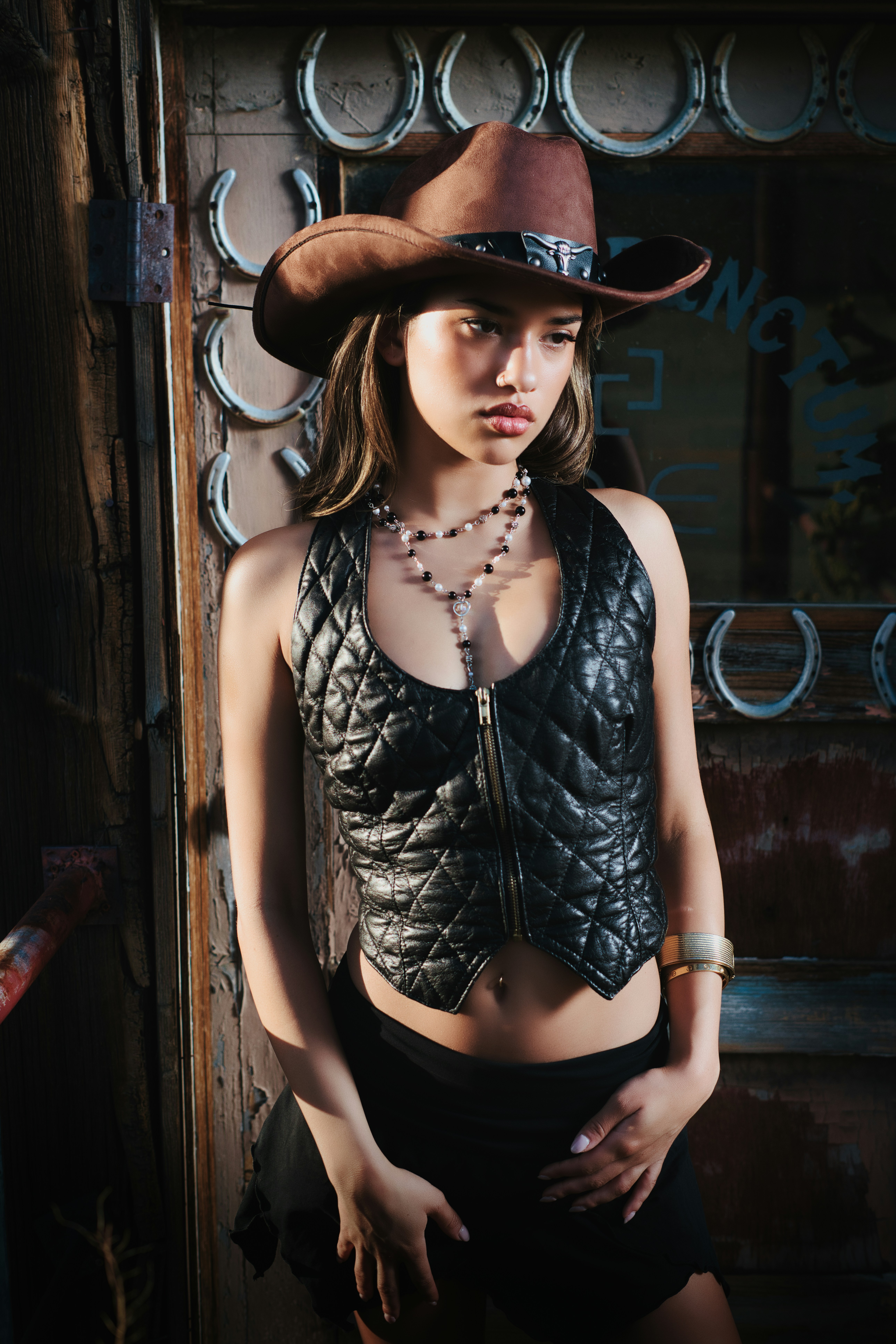 A woman wearing a cowboy hat and leather outfit