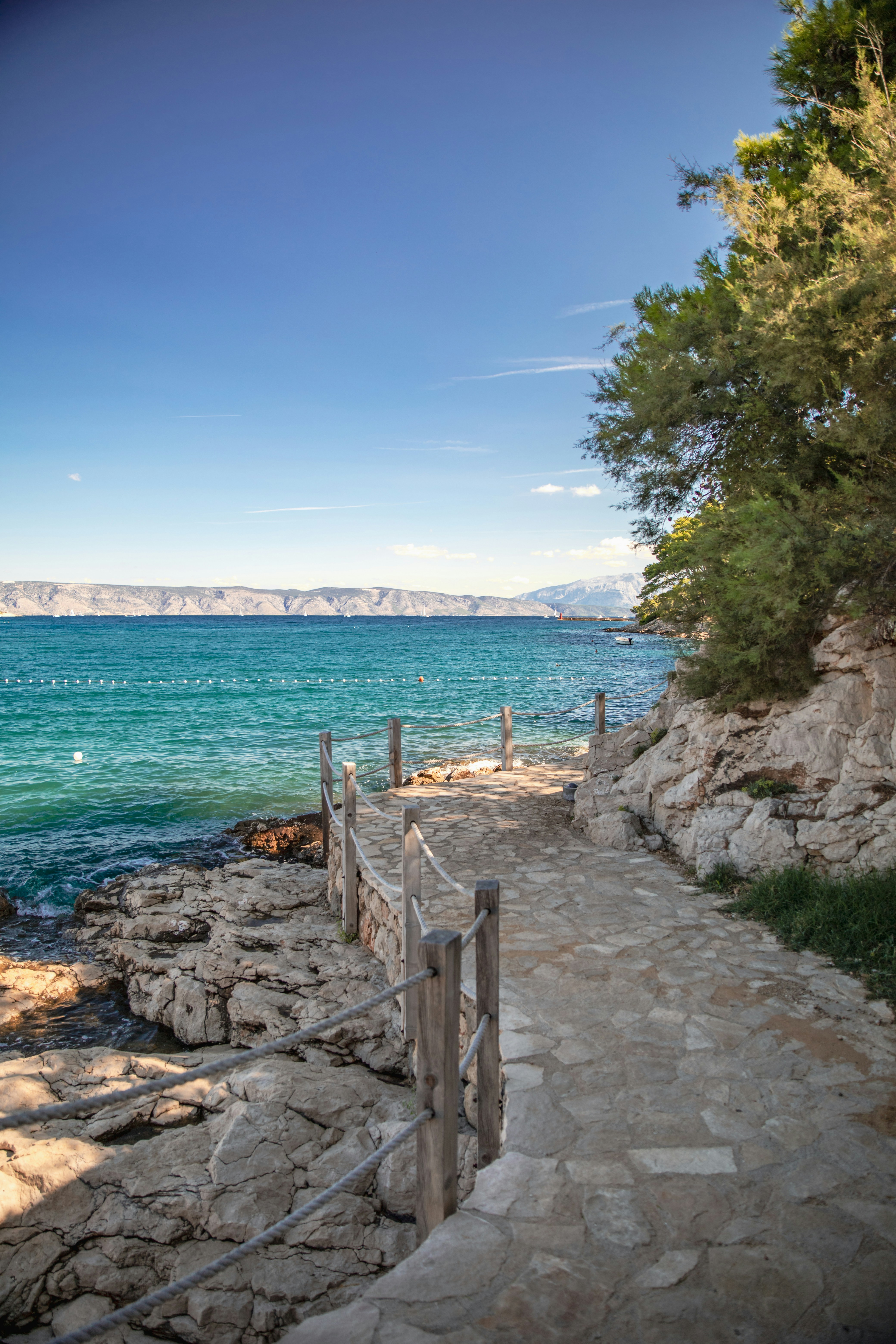 Ein Steinweg, der an einem sonnigen Tag zum Meer führt