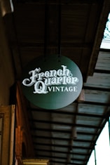 A sign hanging from the side of a building