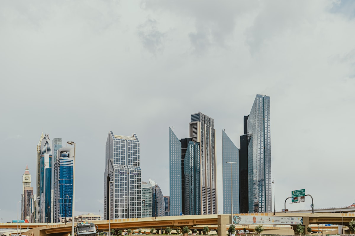 Towers along Sheikh Zayed Road in Dubai's financial district under an overcast sky.