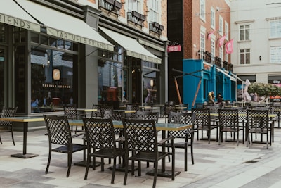 A row of tables and chairs sitting on a sidewalk