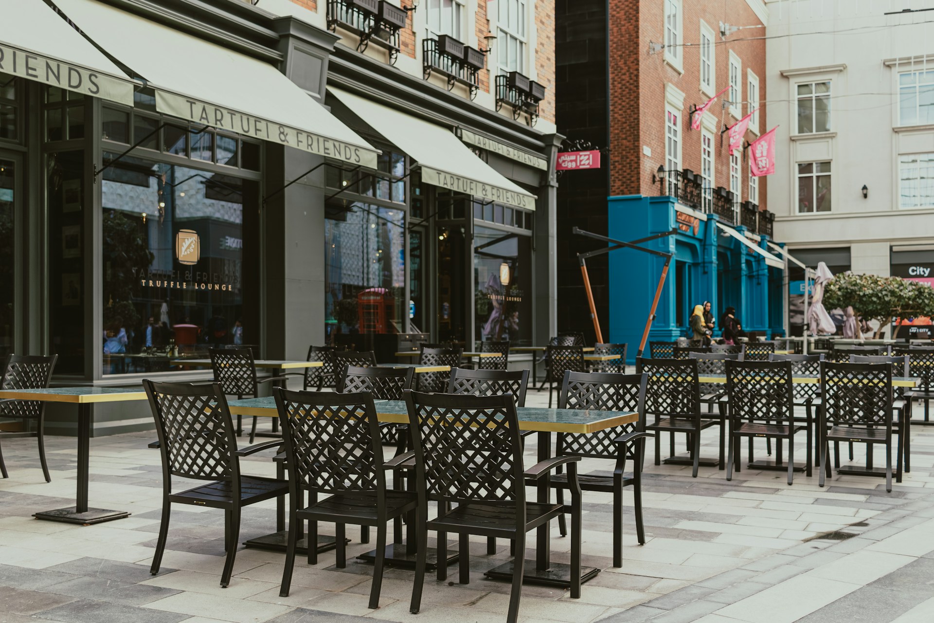 A row of tables and chairs sitting on a sidewalk
