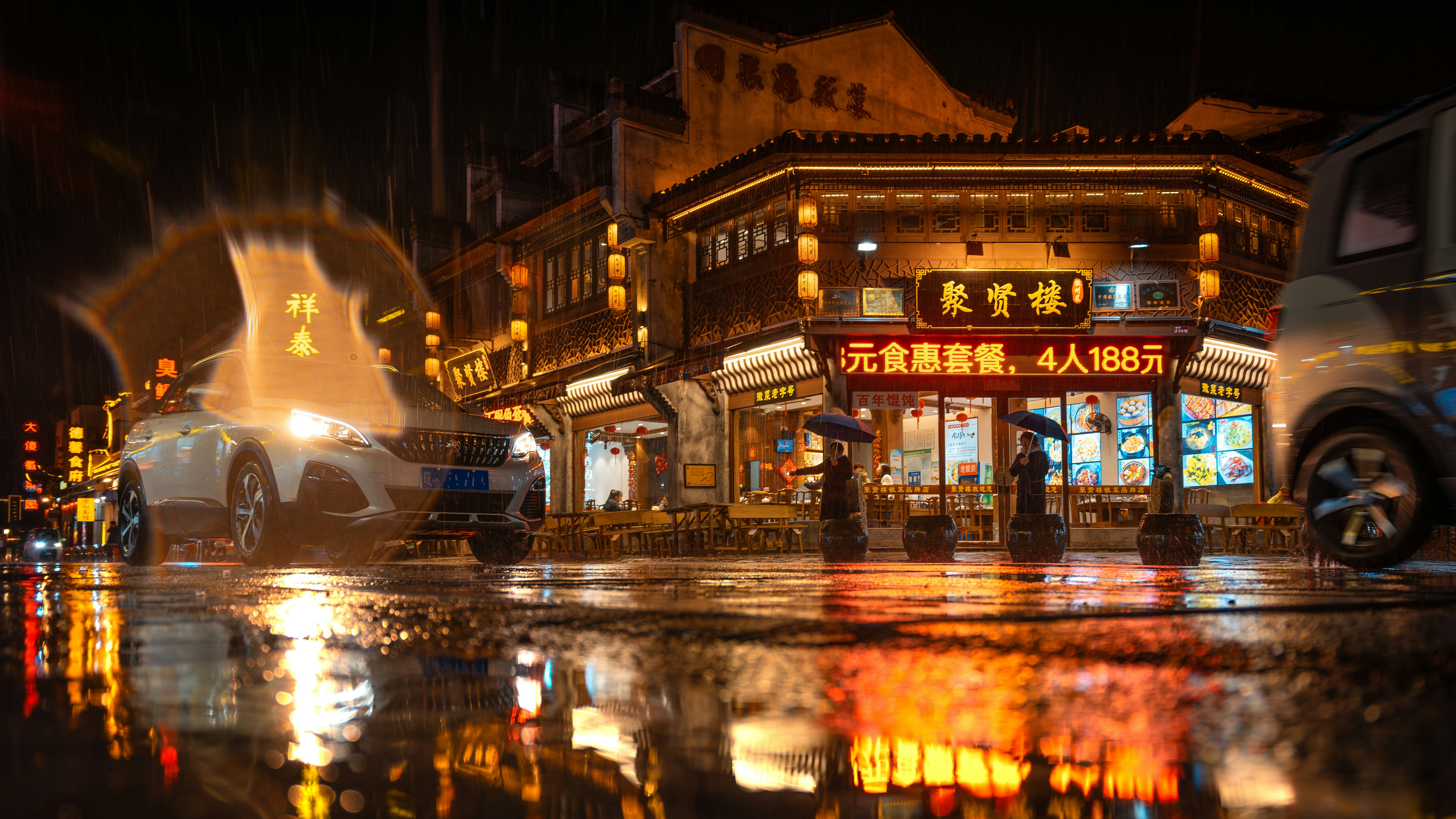 A city street at night with a car parked on the side of the street