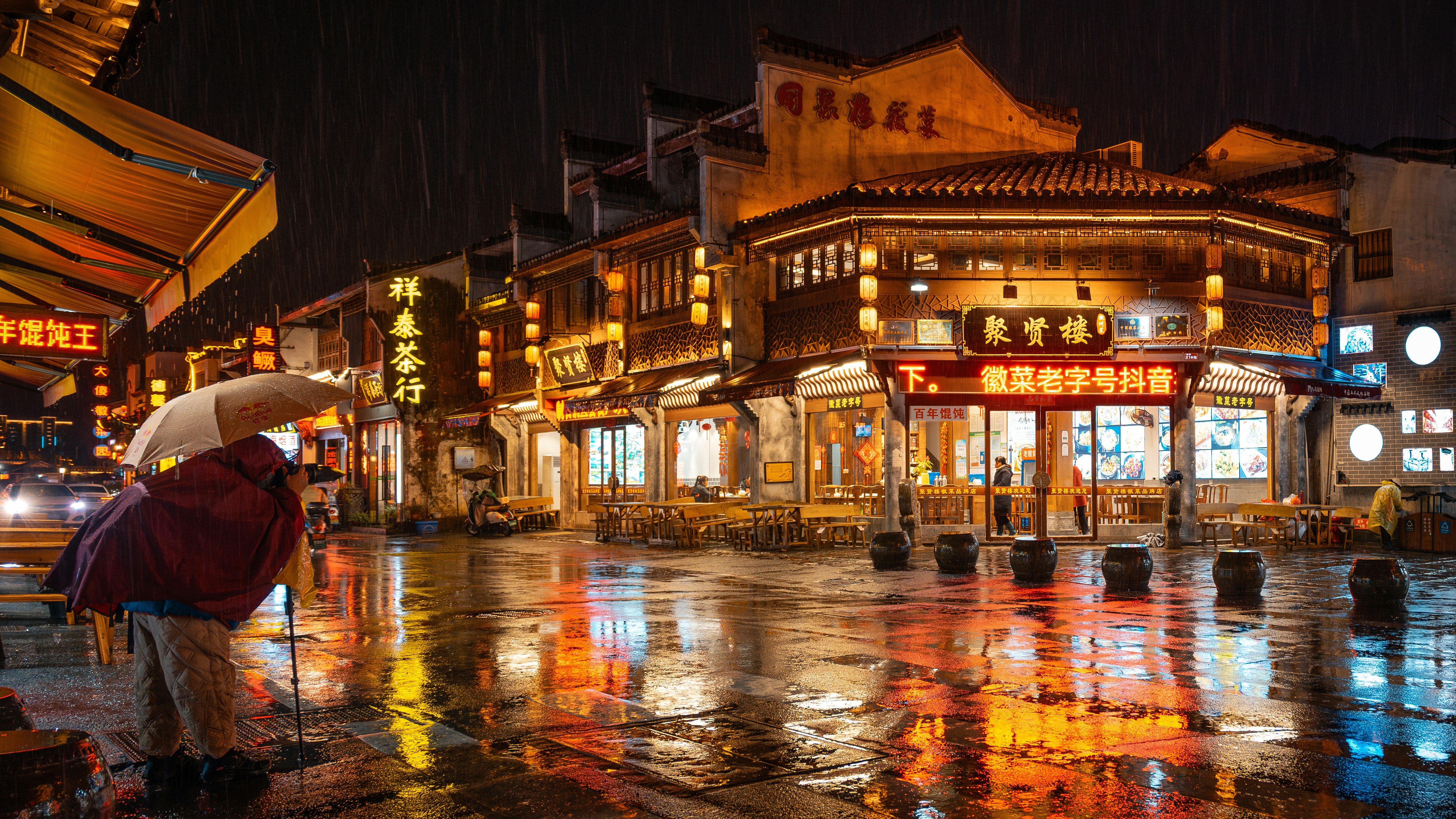 A person with an umbrella standing in the rain