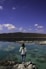 A person standing on a rock near a body of water