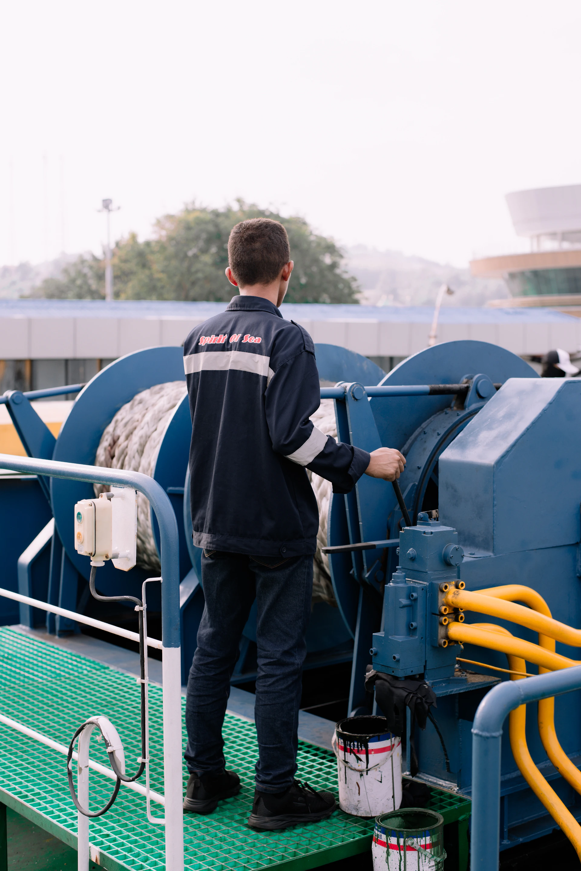 A man standing on top of a green platform next to a machine
