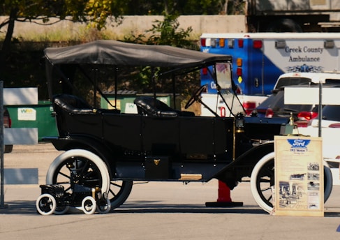 An old fashioned car parked in a parking lot