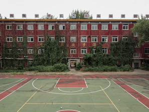A basketball court in front of a red building