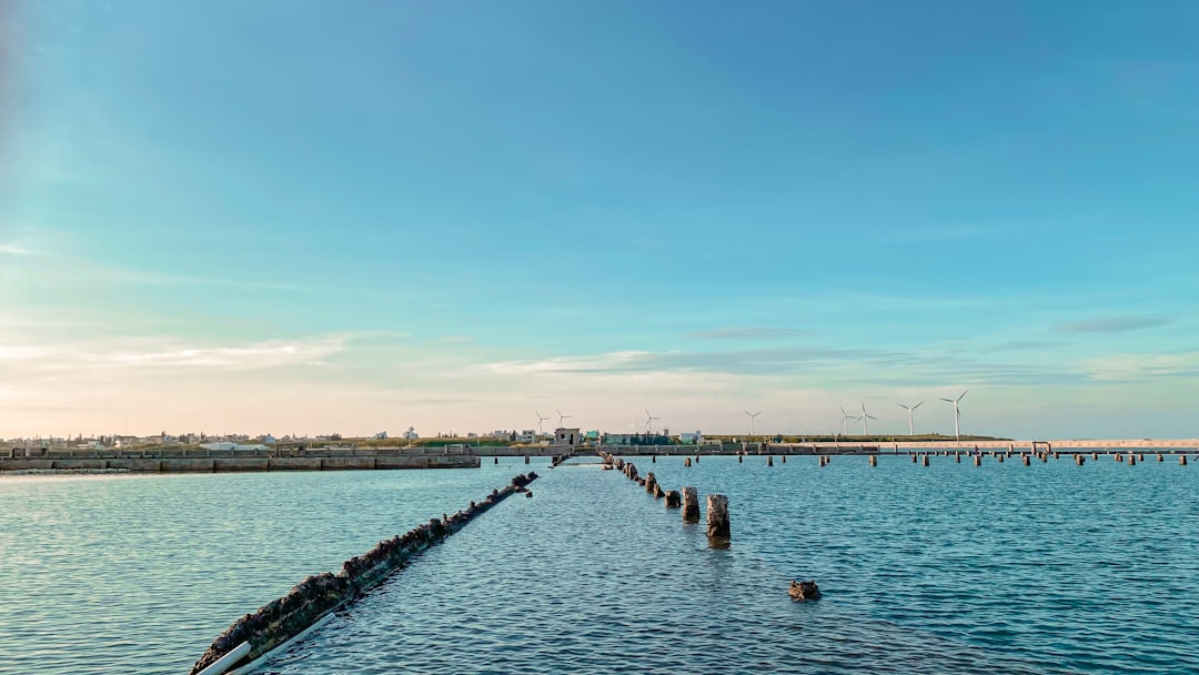 A large body of water sitting under a blue sky, Sunset