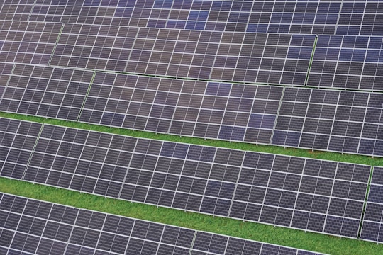 A row of rows of solar panels in a field