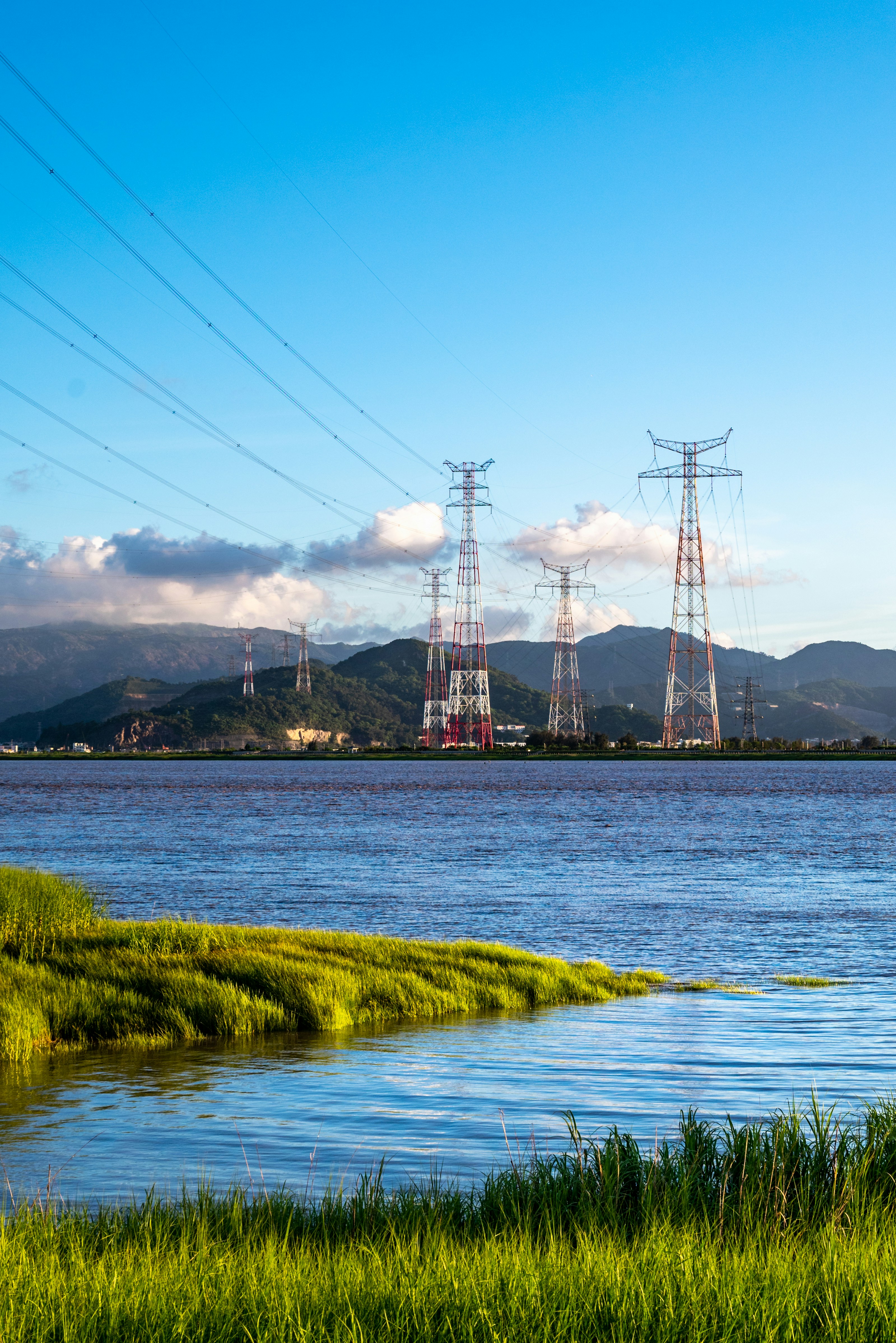 A body of water surrounded by power lines