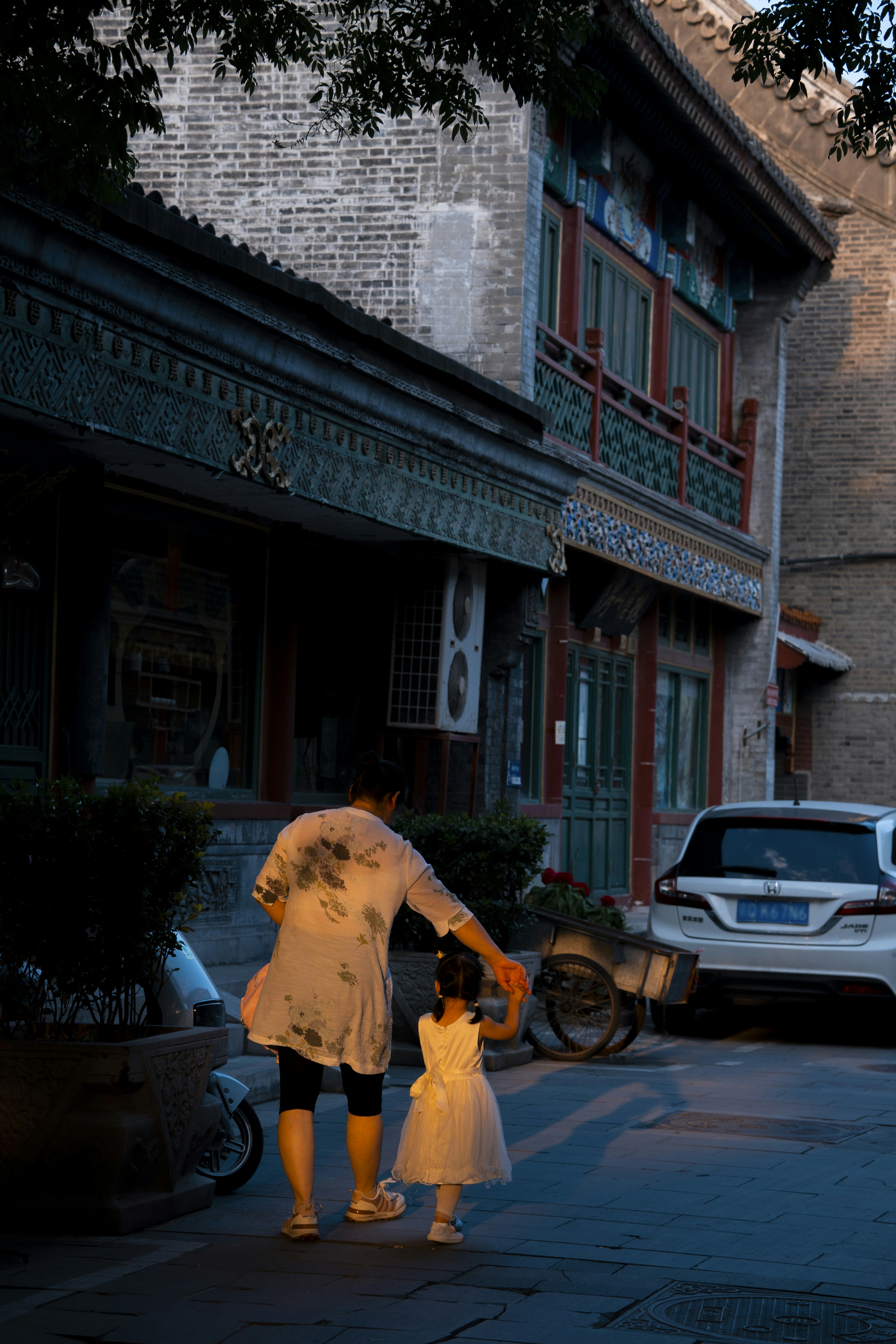 A woman and a child walking down a street