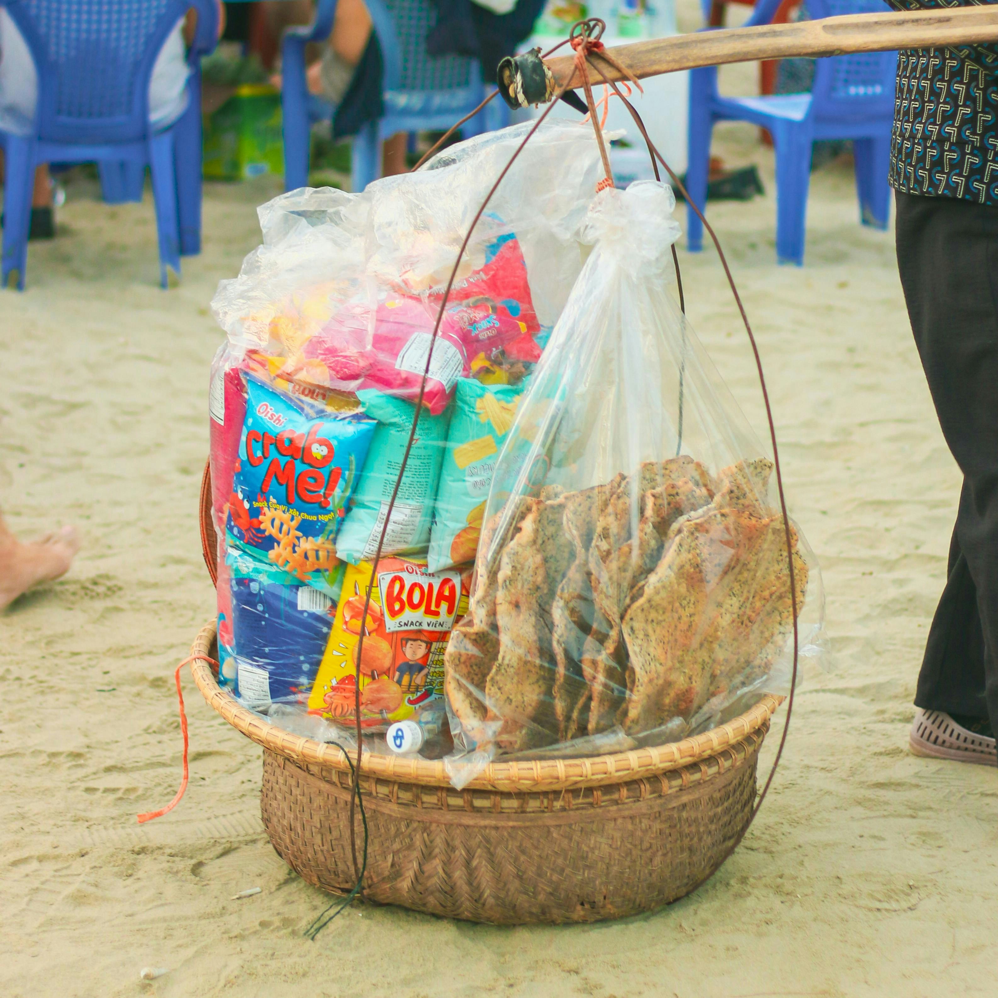 A person carrying a basket of food on a beach