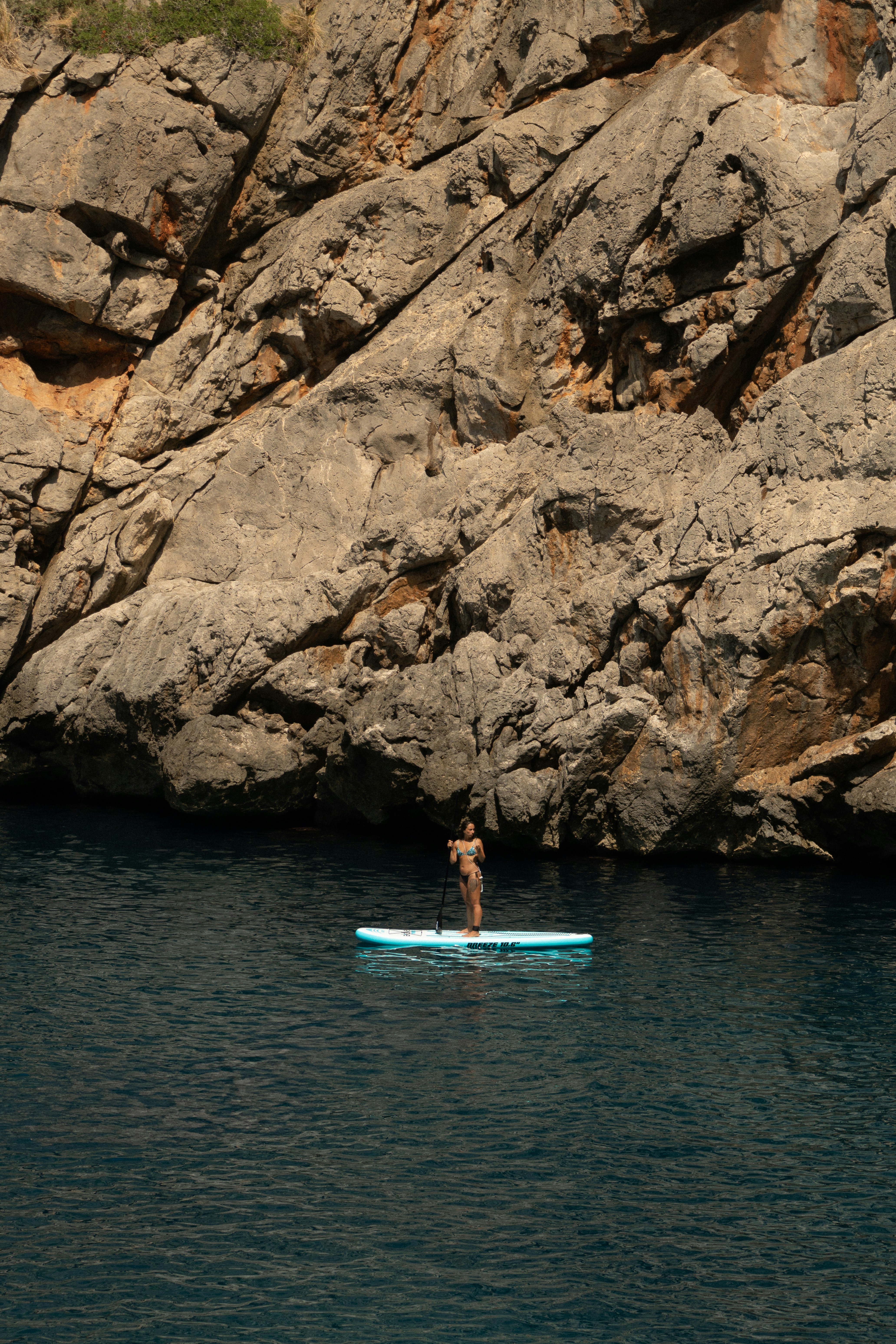 A man standing on a surfboard in the middle of a body of water