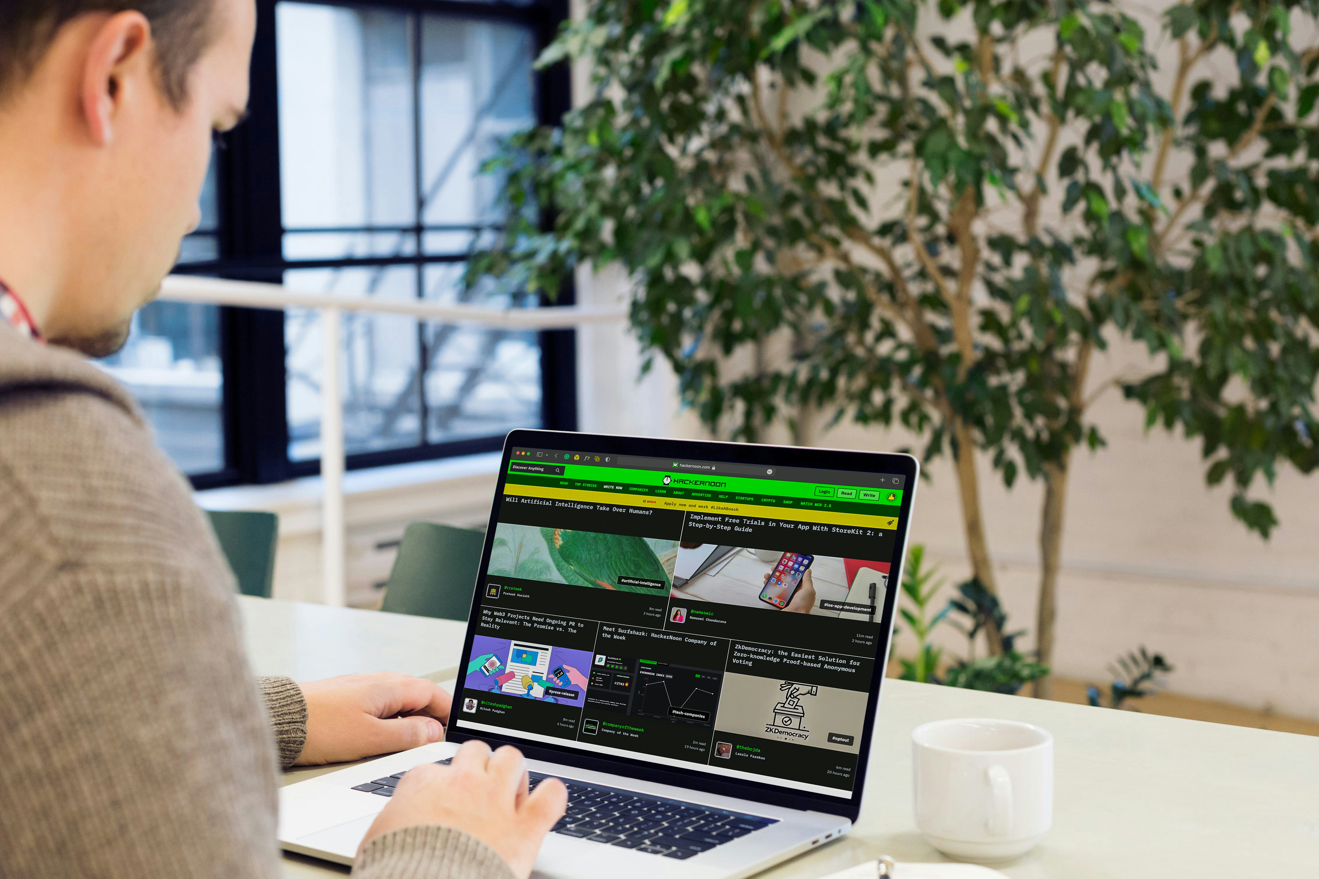 A man sitting at a desk using a laptop computer
