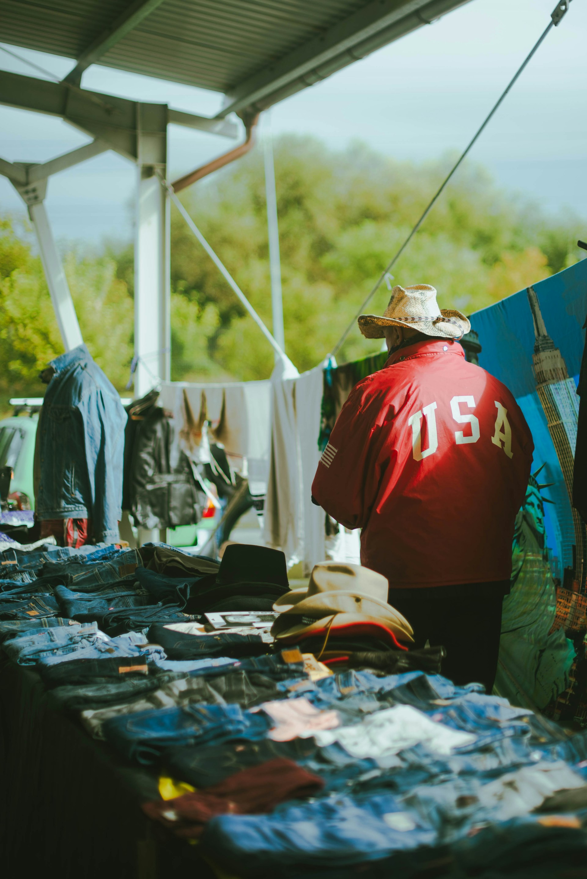 A man standing next to a table filled with clothes