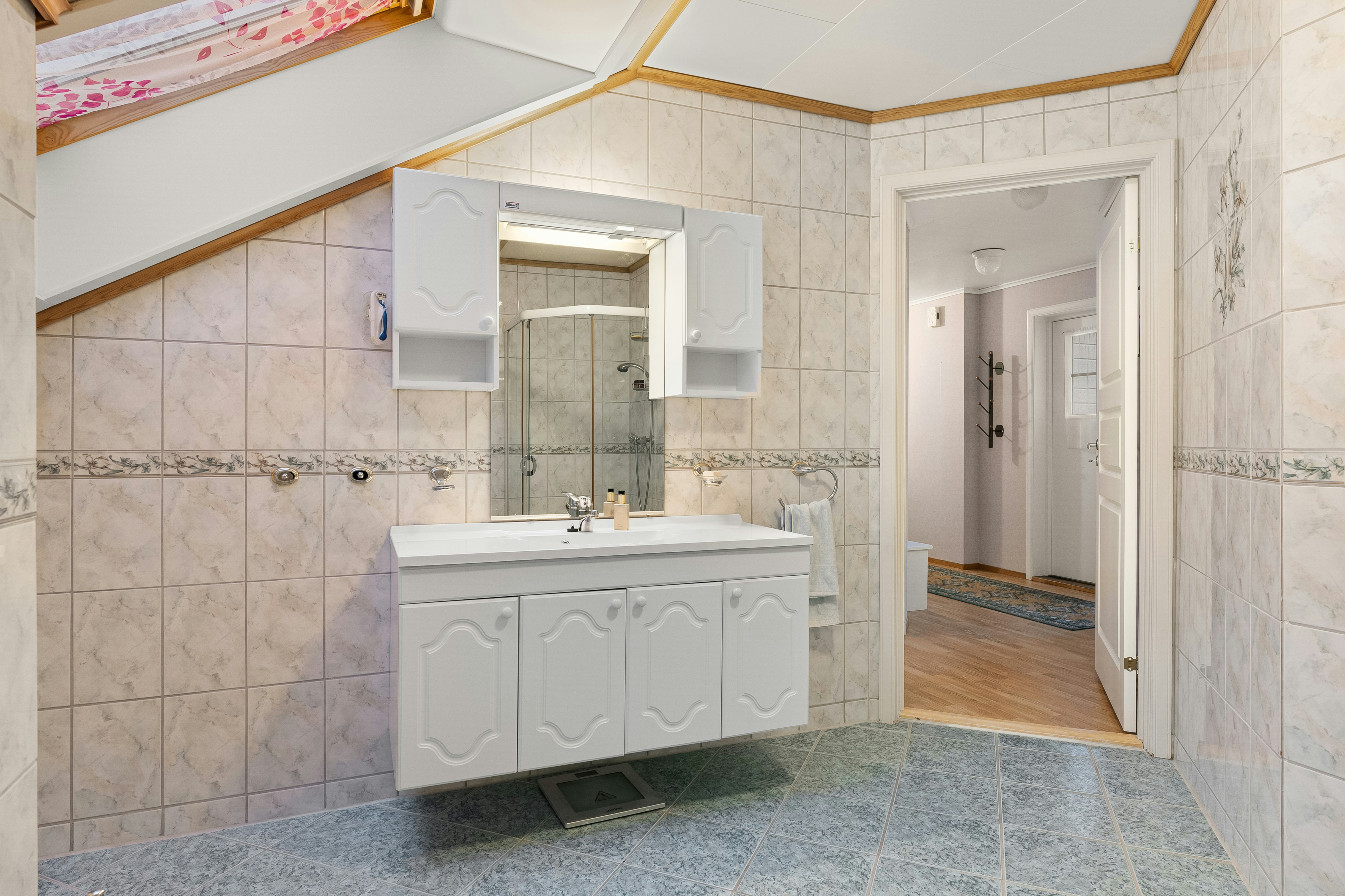 A bathroom with a sink, mirror, and shower