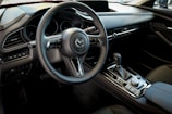 The interior of a car with a steering wheel and dashboard