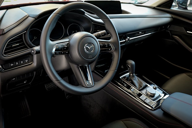 The interior of a car with a steering wheel and dashboard