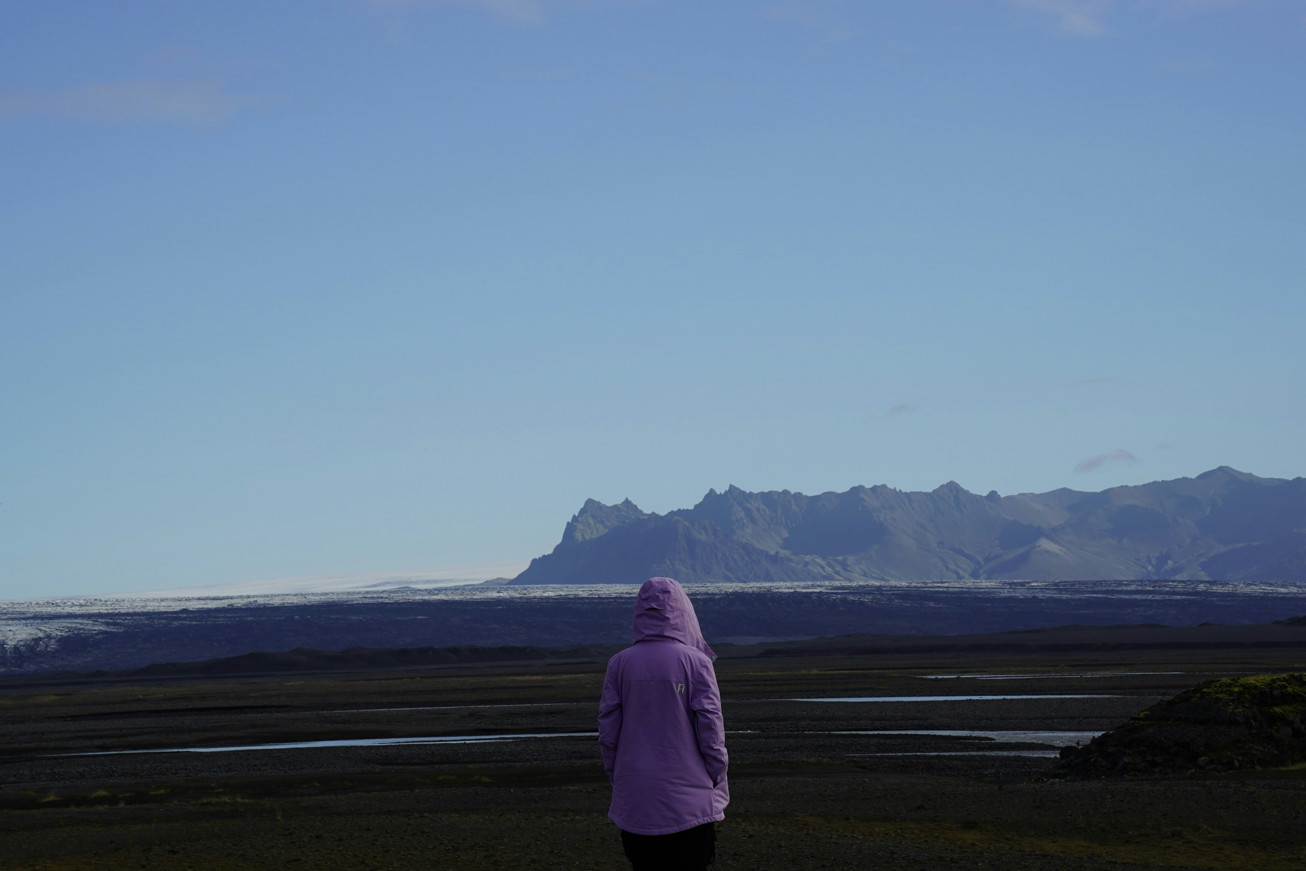 Une personne profite respectueusement de la nature islandaise en faisant voler un cerf-volant dans un grand espace ouvert.